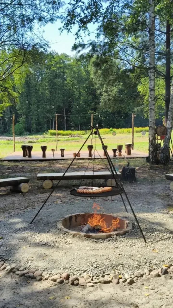 Ognisko w kamiennym kręgu, nad nim trójnóg z rusztem