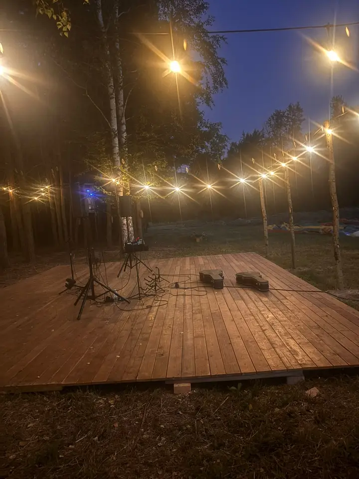 Scena ze sprzętem nagłośnieniowym pod girlandami wieczorem